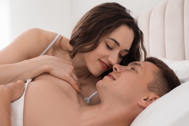 Photo of Lovely couple lying on bed at home