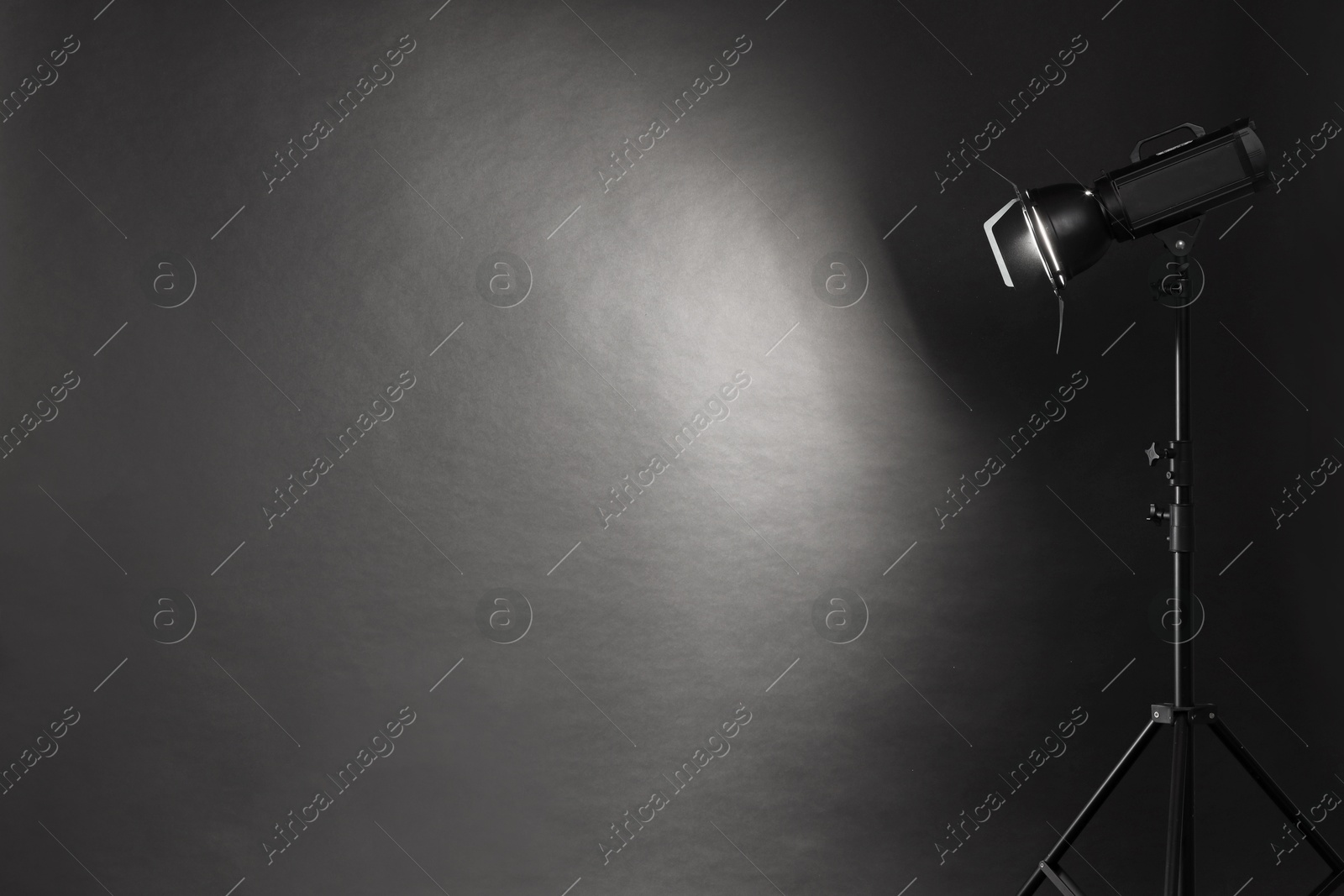 Photo of Dark photo background and professional lighting equipment in studio. Space for text