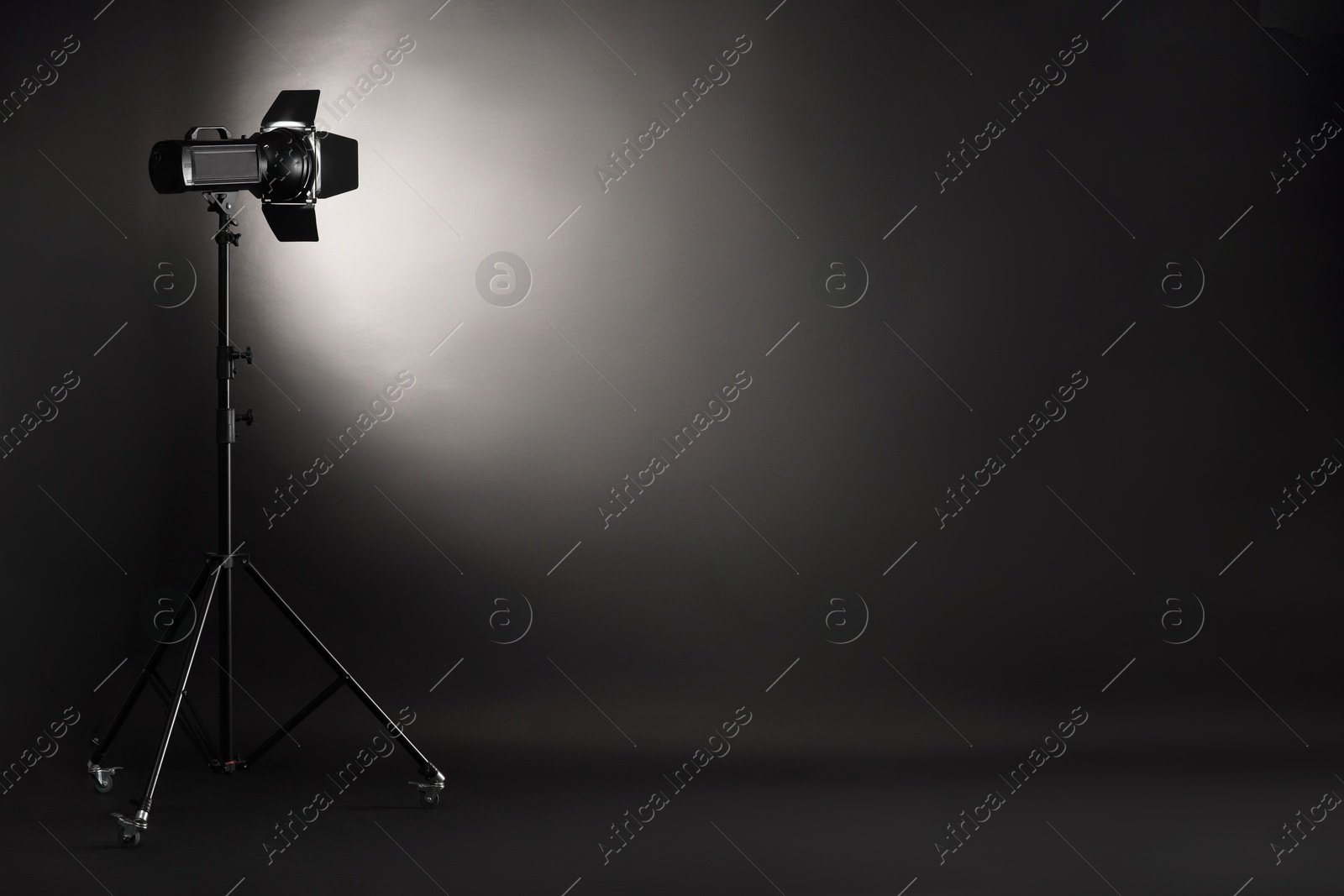 Photo of Dark photo background and professional lighting equipment in studio