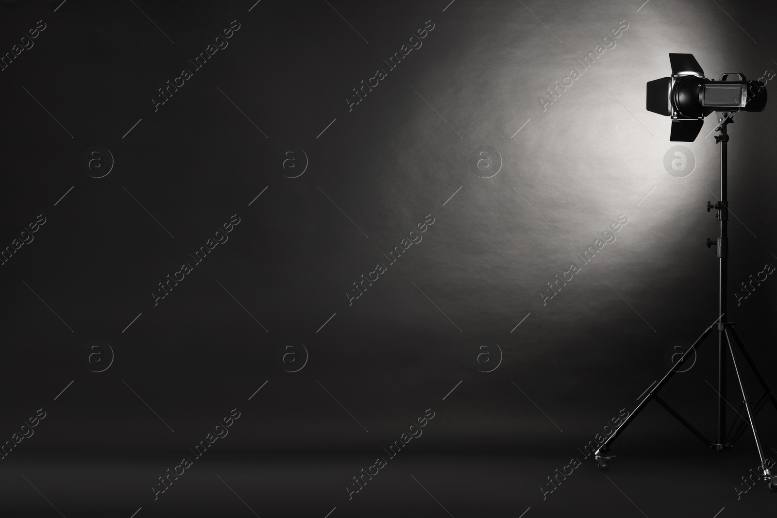 Photo of Dark photo background and professional lighting equipment in studio