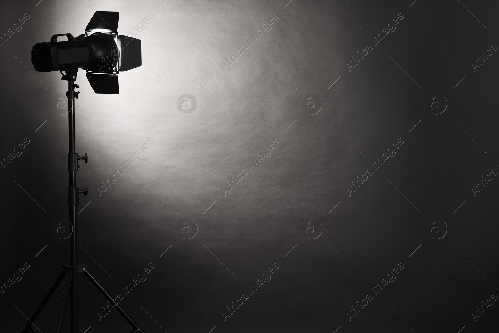 Photo of Dark photo background and professional lighting equipment in studio. Space for text