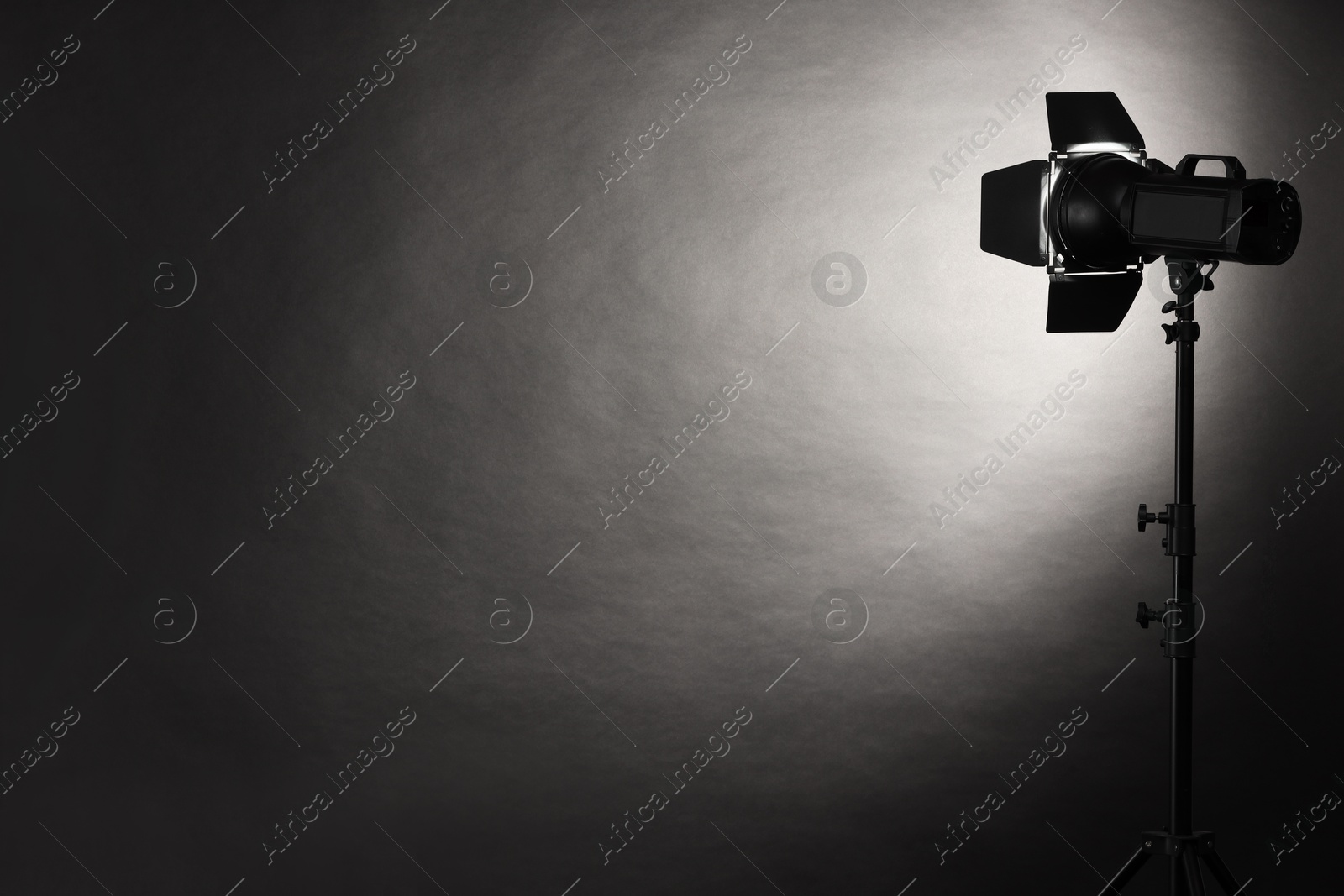 Photo of Dark photo background and professional lighting equipment in studio. Space for text