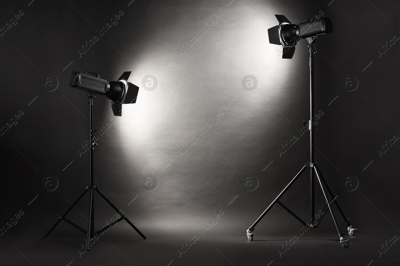 Photo of Dark photo background and professional lighting equipment in studio