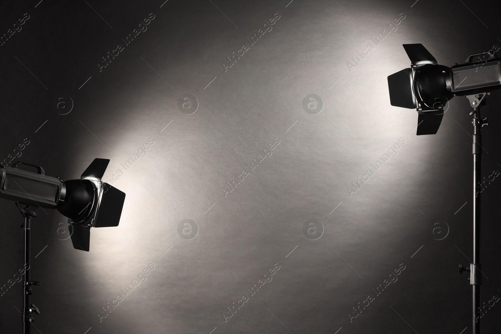 Photo of Dark photo background and professional lighting equipment in studio