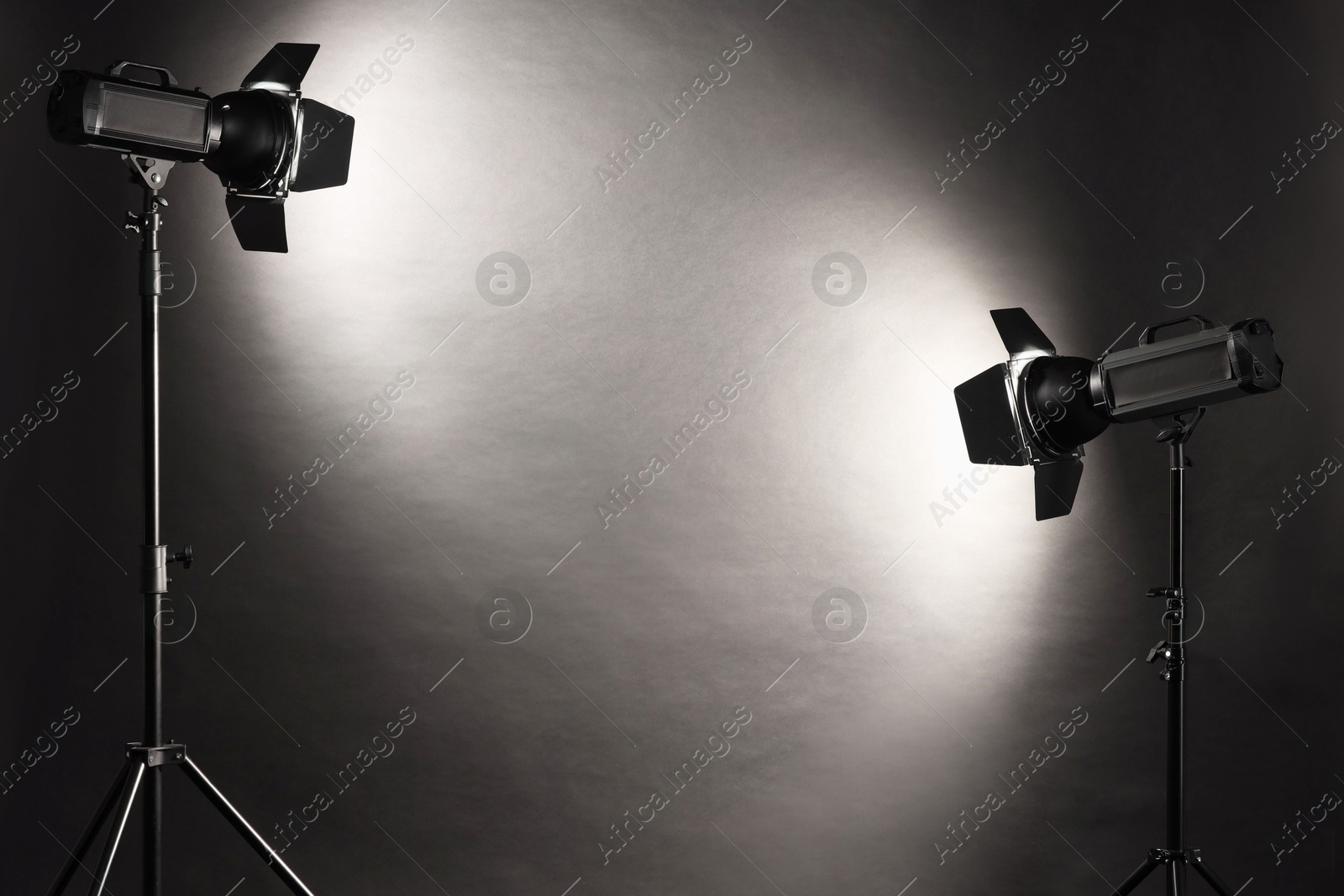 Photo of Dark photo background and professional lighting equipment in studio