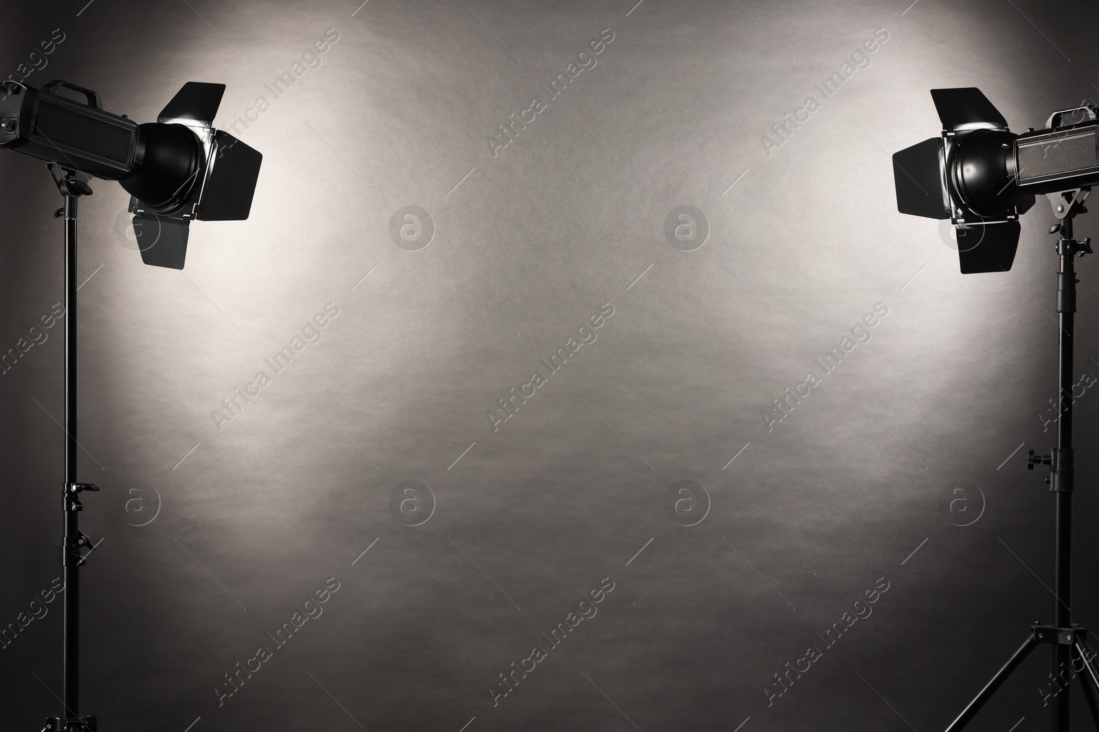 Photo of Dark photo background and professional lighting equipment in studio