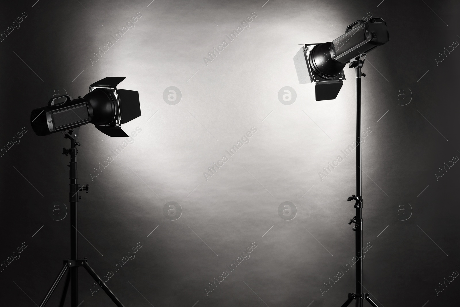 Photo of Dark photo background and professional lighting equipment in studio