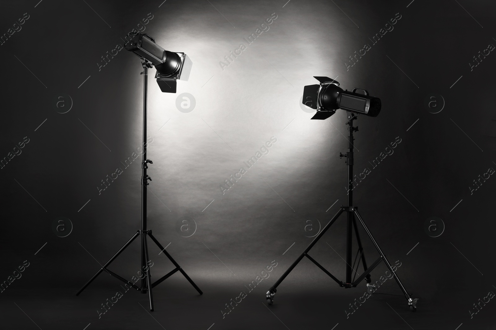 Photo of Dark photo background and professional lighting equipment in studio