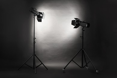 Dark photo background and professional lighting equipment in studio