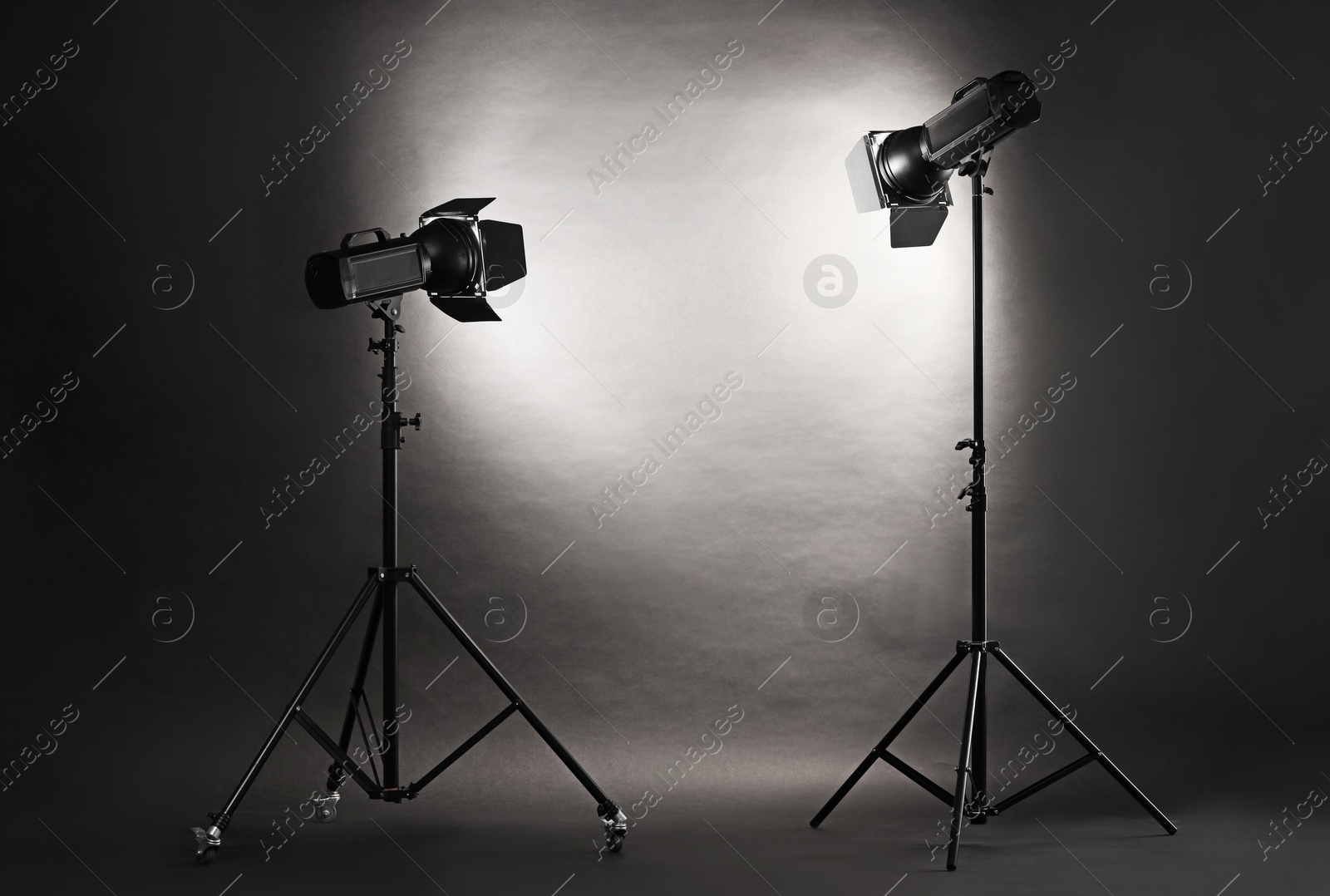 Photo of Dark photo background and professional lighting equipment in studio