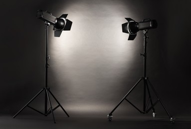 Photo of Dark photo background and professional lighting equipment in studio