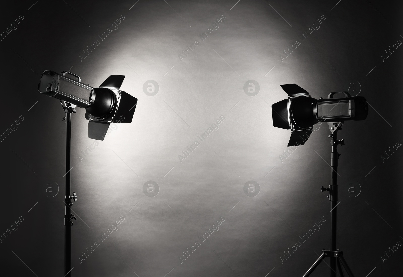 Photo of Dark photo background and professional lighting equipment in studio