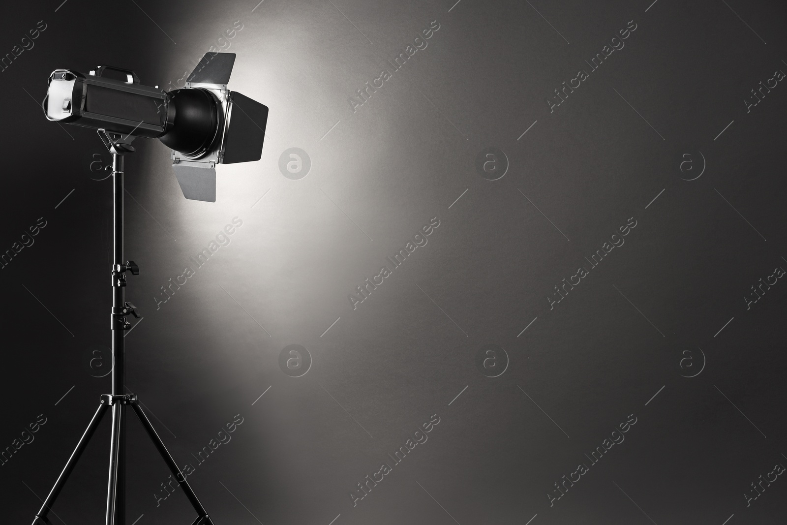 Photo of Dark photo background and professional lighting equipment in studio. Space for text