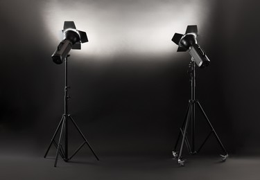 Photo of Dark photo background and professional lighting equipment in studio