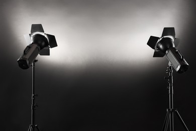 Photo of Dark photo background and professional lighting equipment in studio