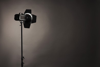 Photo of Dark photo background and professional lighting equipment in studio. Space for text