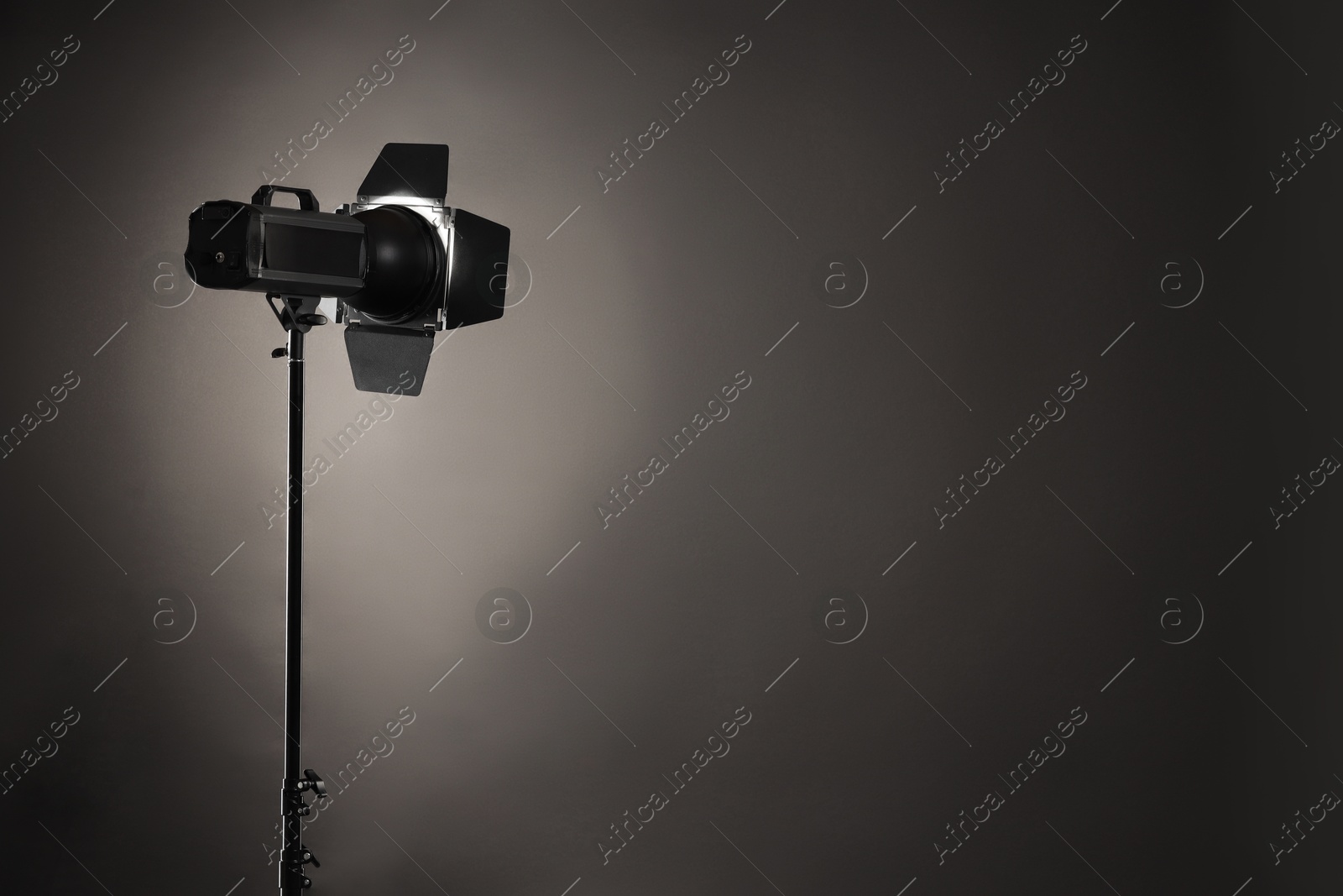 Photo of Dark photo background and professional lighting equipment in studio. Space for text