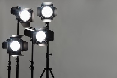 Grey photo background and professional lighting equipment in studio. Space for text