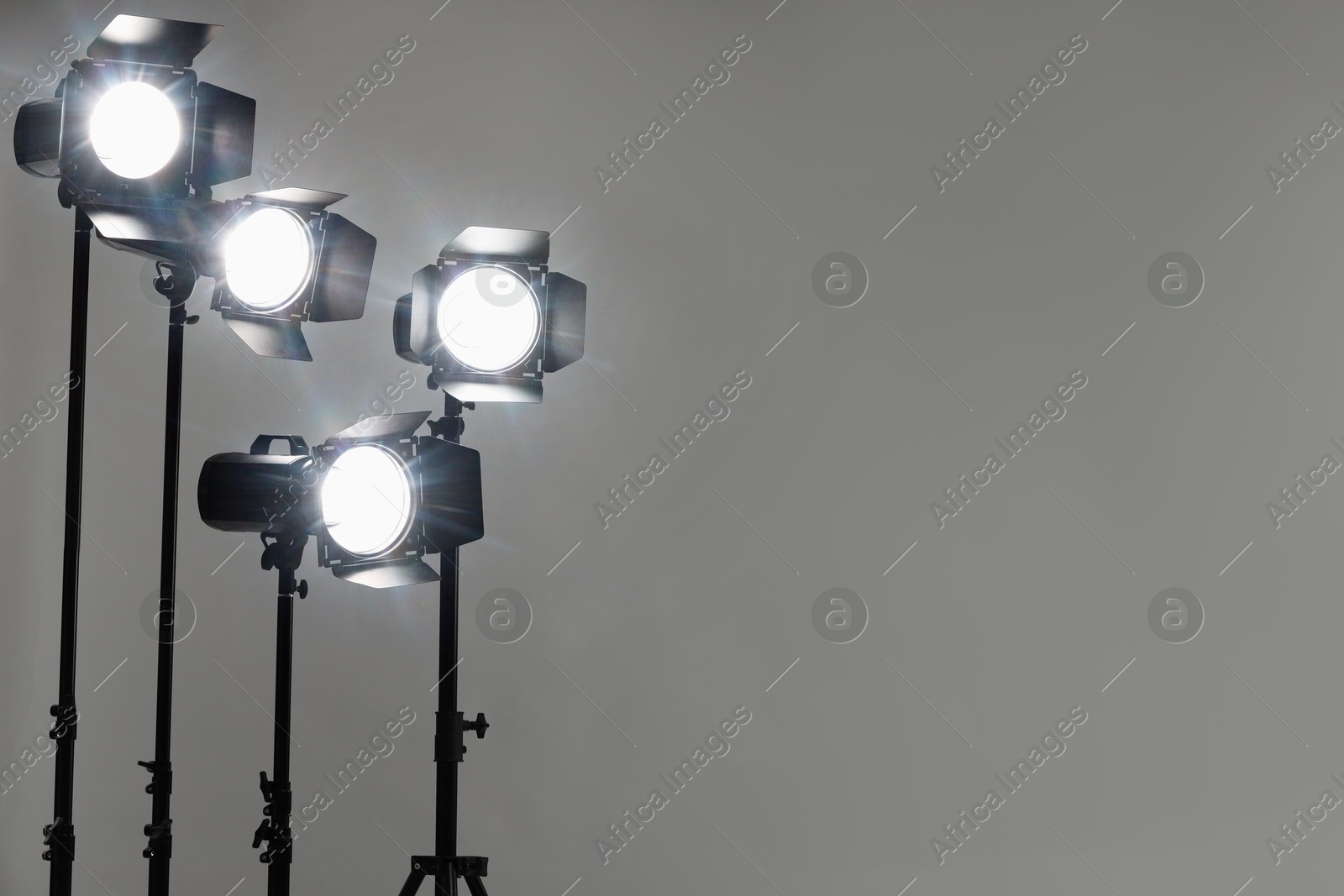 Photo of Grey photo background and professional lighting equipment in studio. Space for text