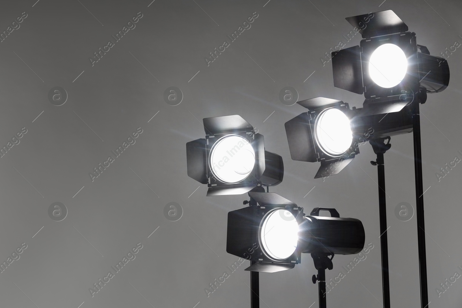 Photo of Grey photo background and professional lighting equipment in studio. Space for text