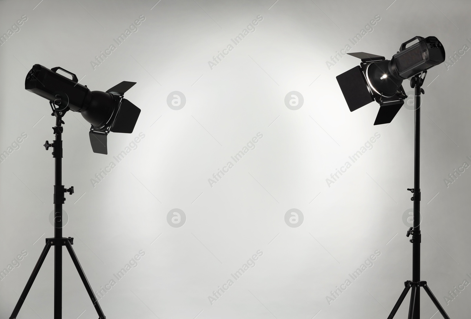 Photo of Grey photo background and professional lighting equipment in studio