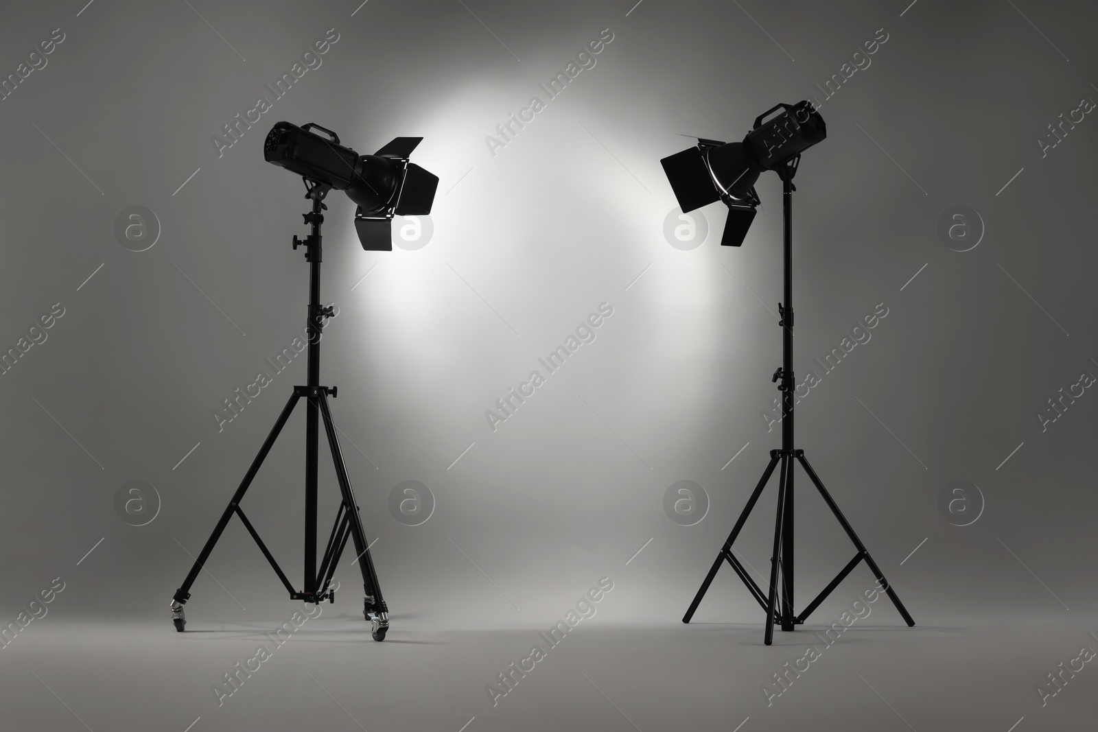 Photo of Grey photo background and professional lighting equipment in studio