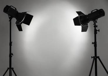 Grey photo background and professional lighting equipment in studio