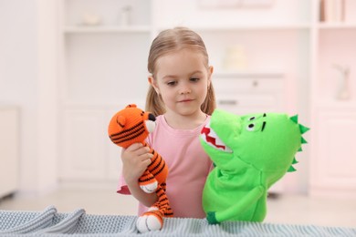 Puppet theatre. Cute girl performing show with toys at home