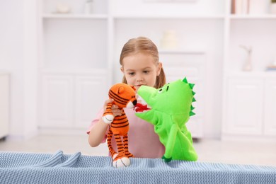 Photo of Puppet theatre. Cute girl performing show with toys at home