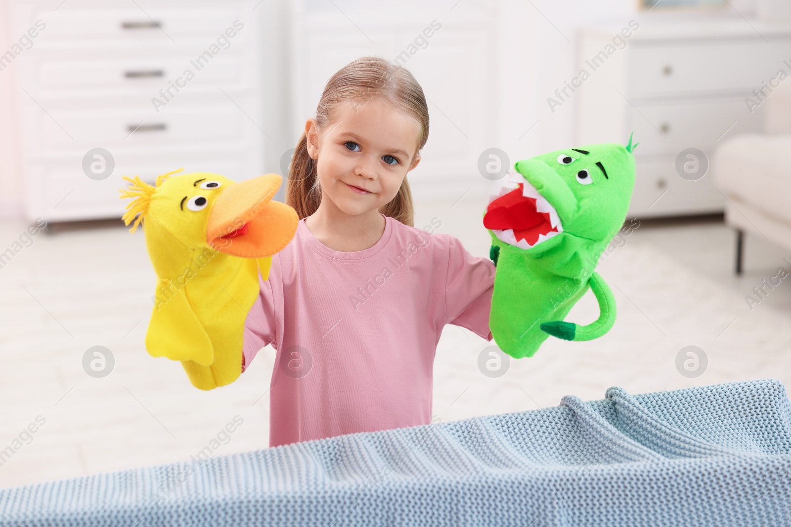 Photo of Puppet theatre. Cute girl performing show with toys at home