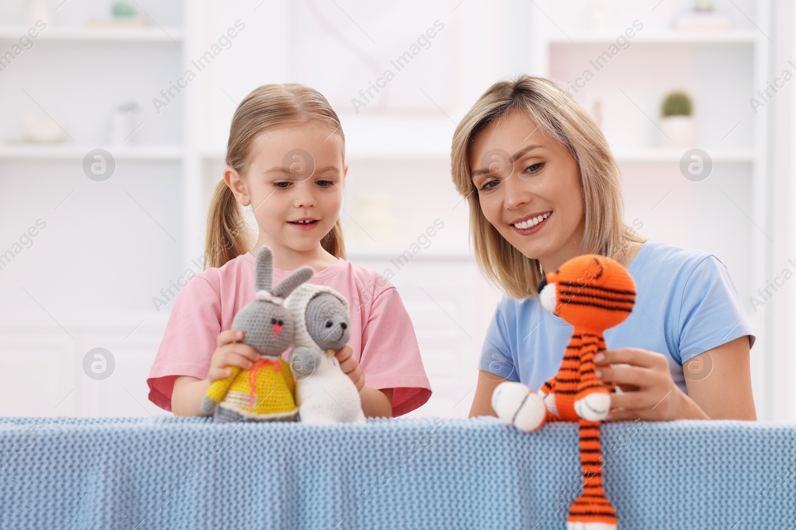 Photo of Puppet theatre. Mother and daughter performing show at home