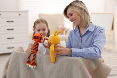 Photo of Puppet theatre. Smiling mother and daughter performing show at home