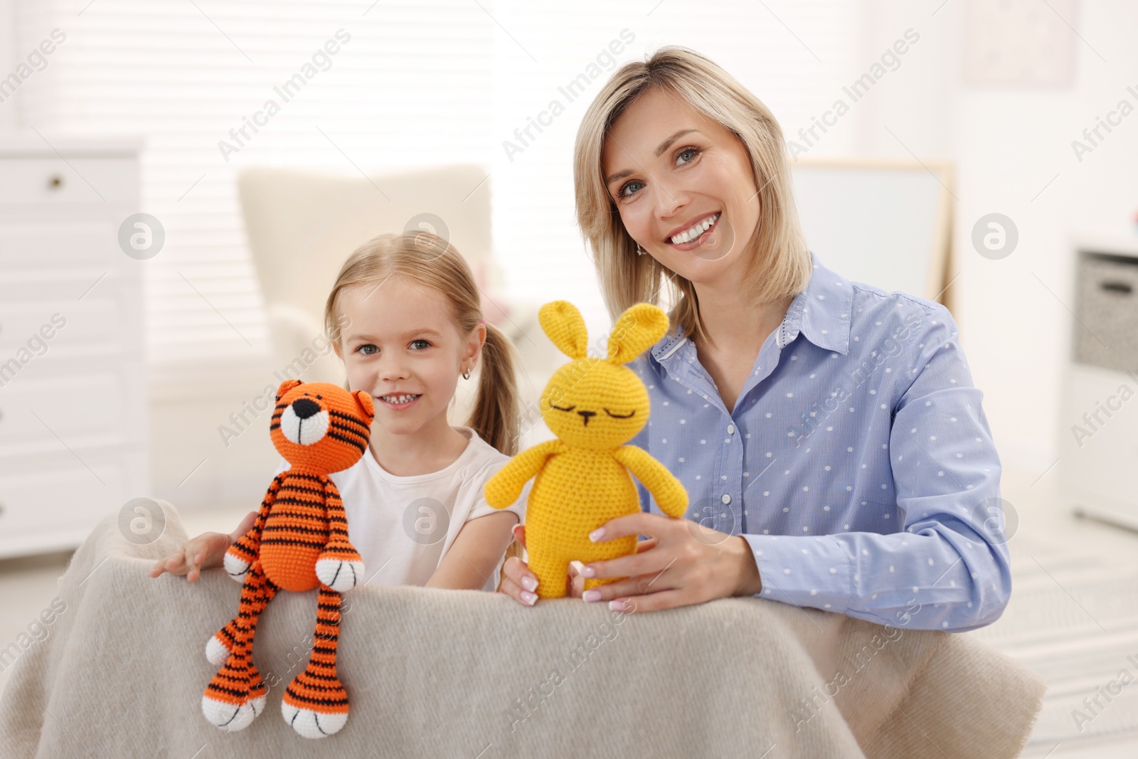 Photo of Puppet theatre. Smiling mother and daughter performing show at home