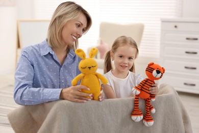 Photo of Puppet theatre. Smiling mother and daughter performing show at home