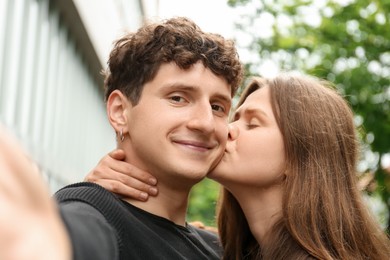 Photo of International dating. Lovely young couple taking selfie outdoors