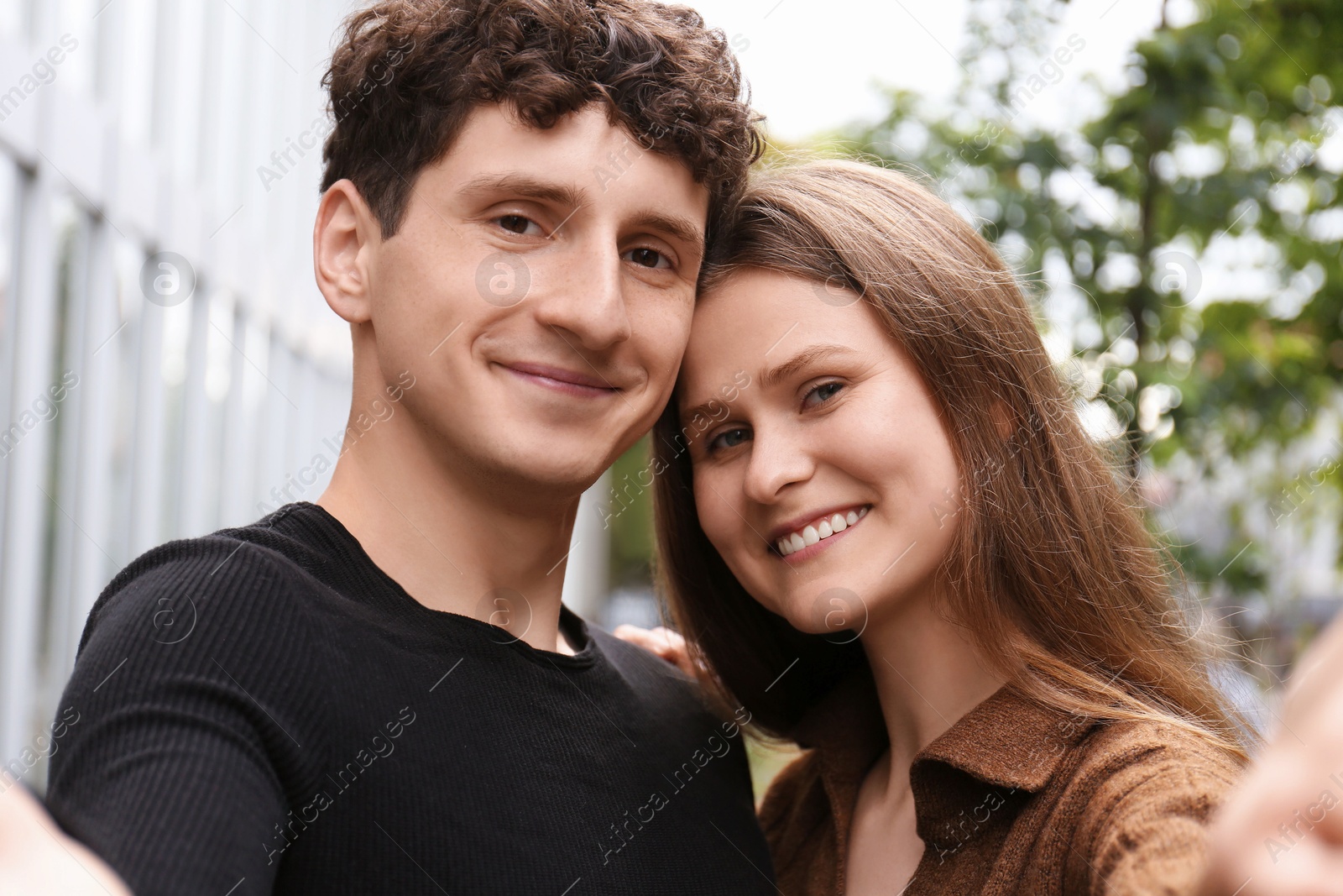 Photo of International dating. Lovely young couple taking selfie outdoors
