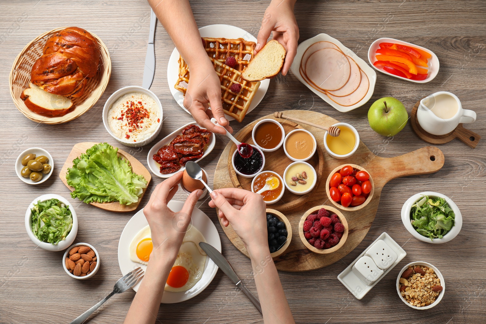 Photo of People having breakfast at wooden table, top view