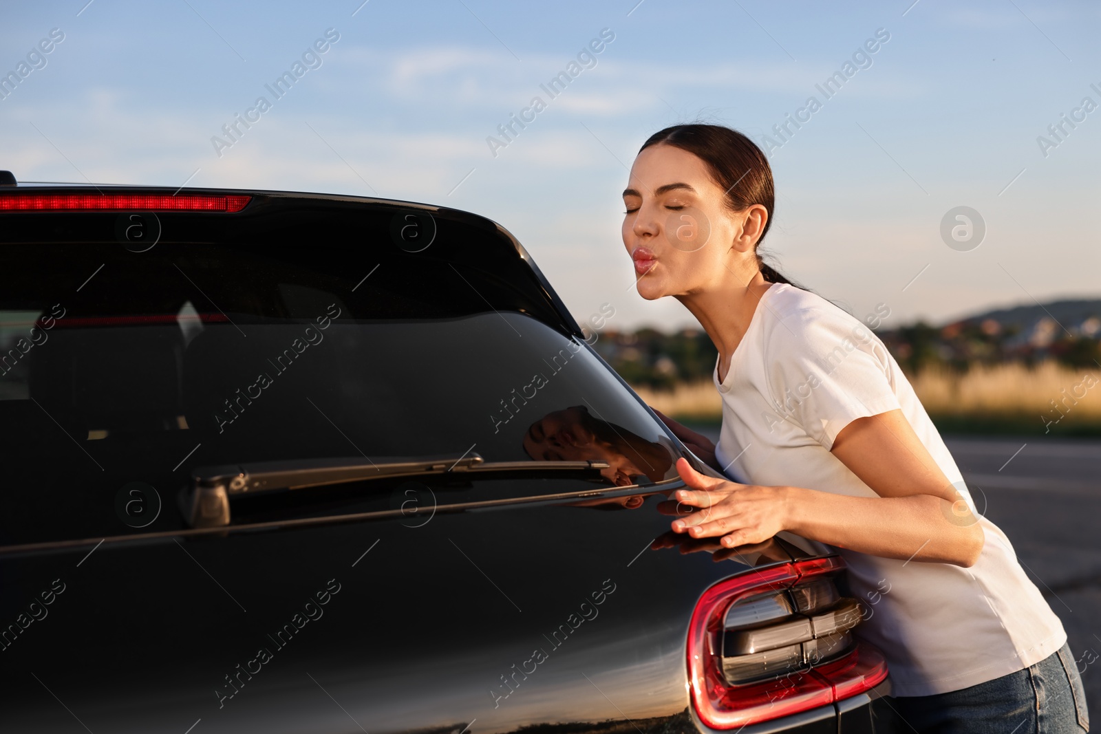 Photo of Beautiful young woman near her new car outdoors