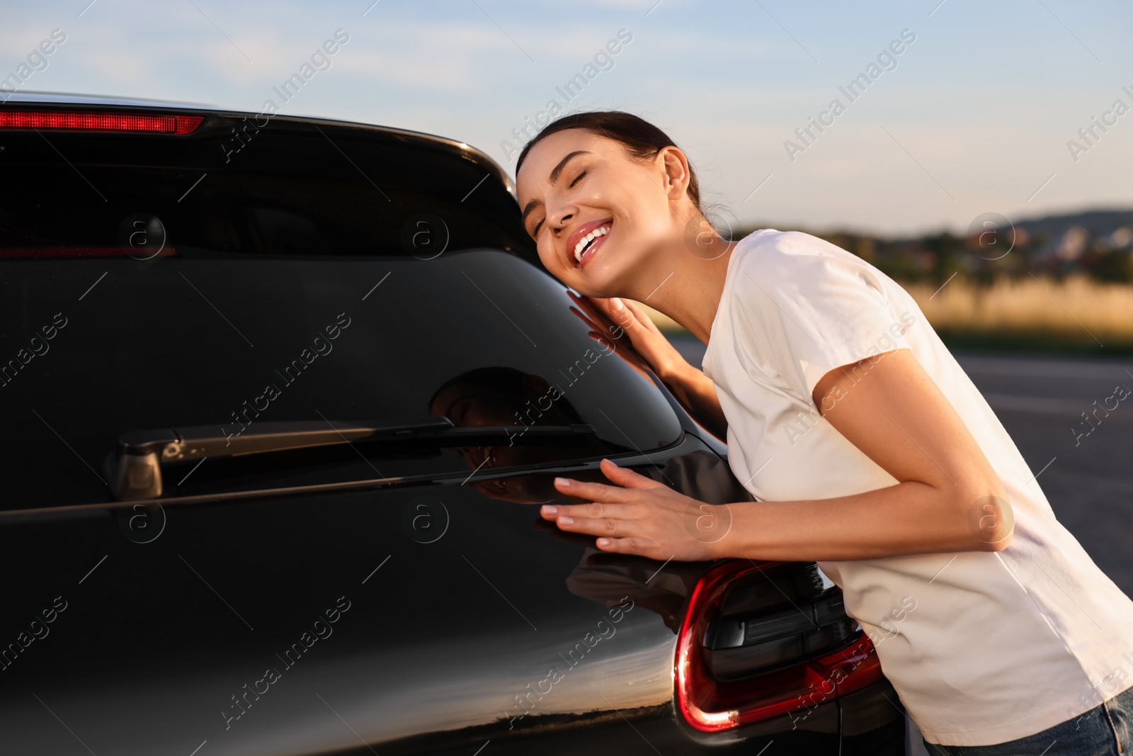 Photo of Happy young woman near her new car outdoors