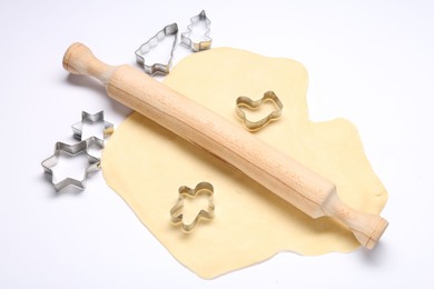 Photo of Raw dough, wooden rolling pin and cookie cutters isolated on white