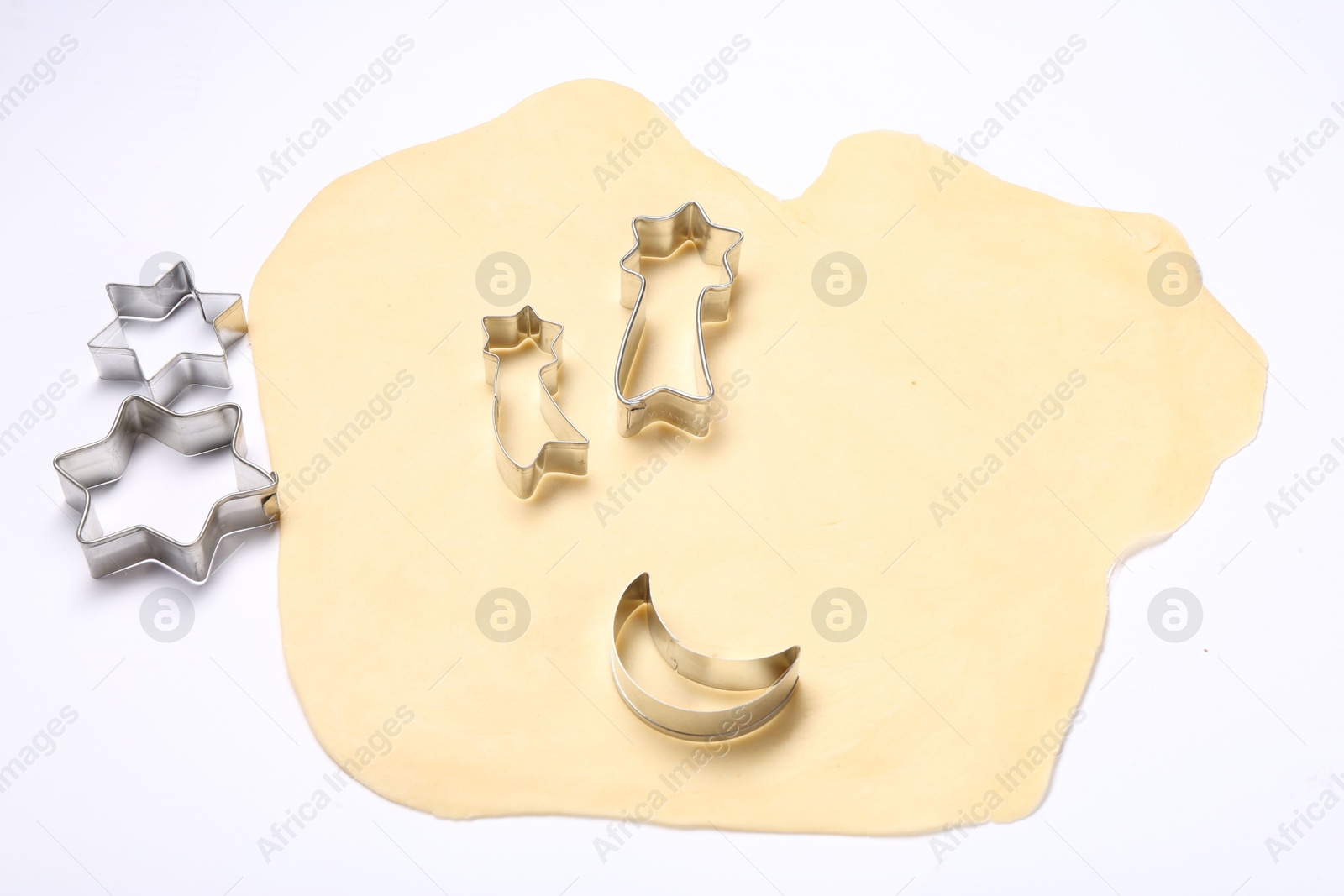 Photo of Raw dough and cookie cutters isolated on white