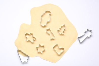 Raw dough and cookie cutters isolated on white, top view