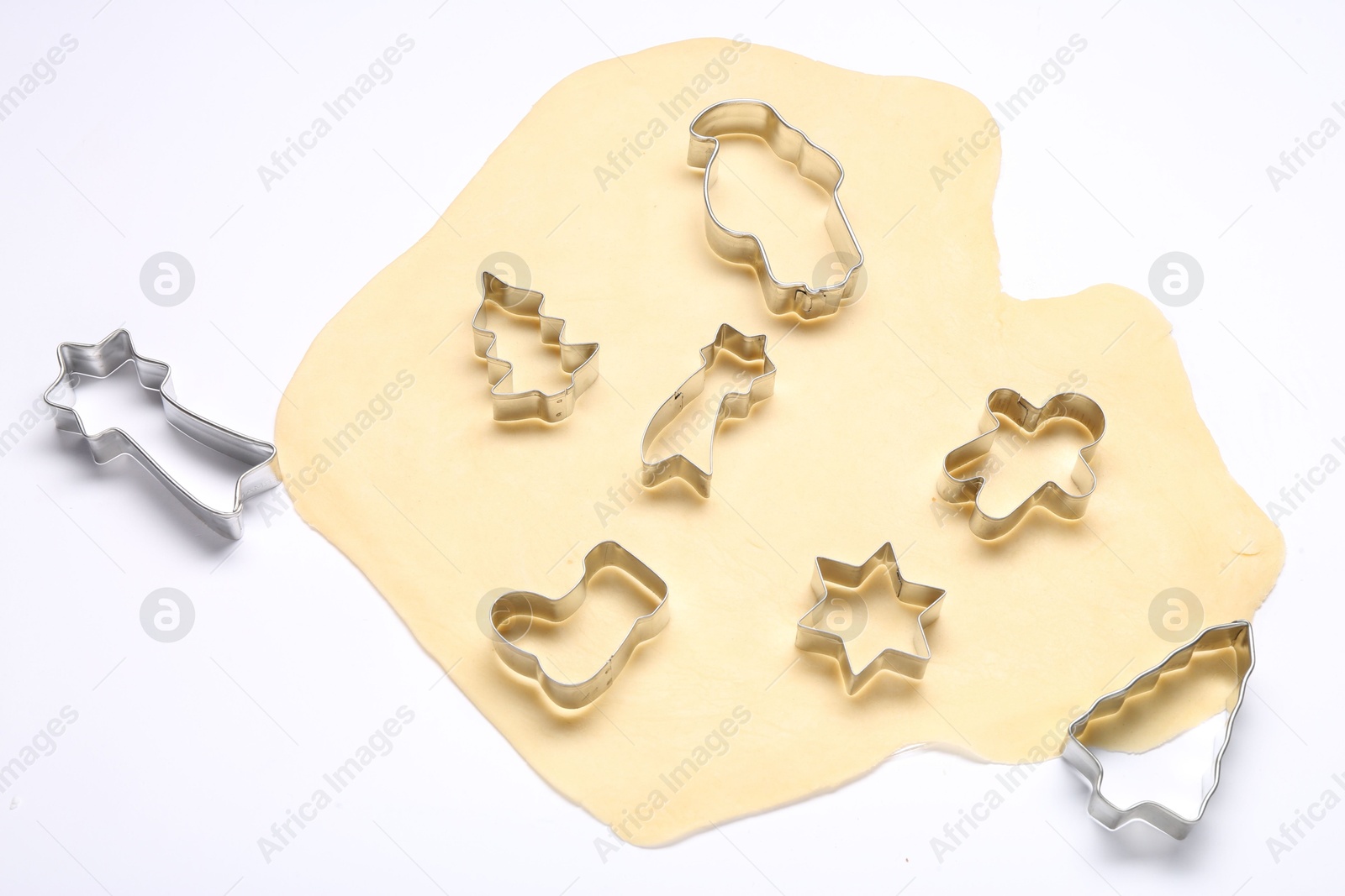 Photo of Raw dough and cookie cutters isolated on white, above view