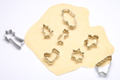 Photo of Raw dough and cookie cutters isolated on white, above view