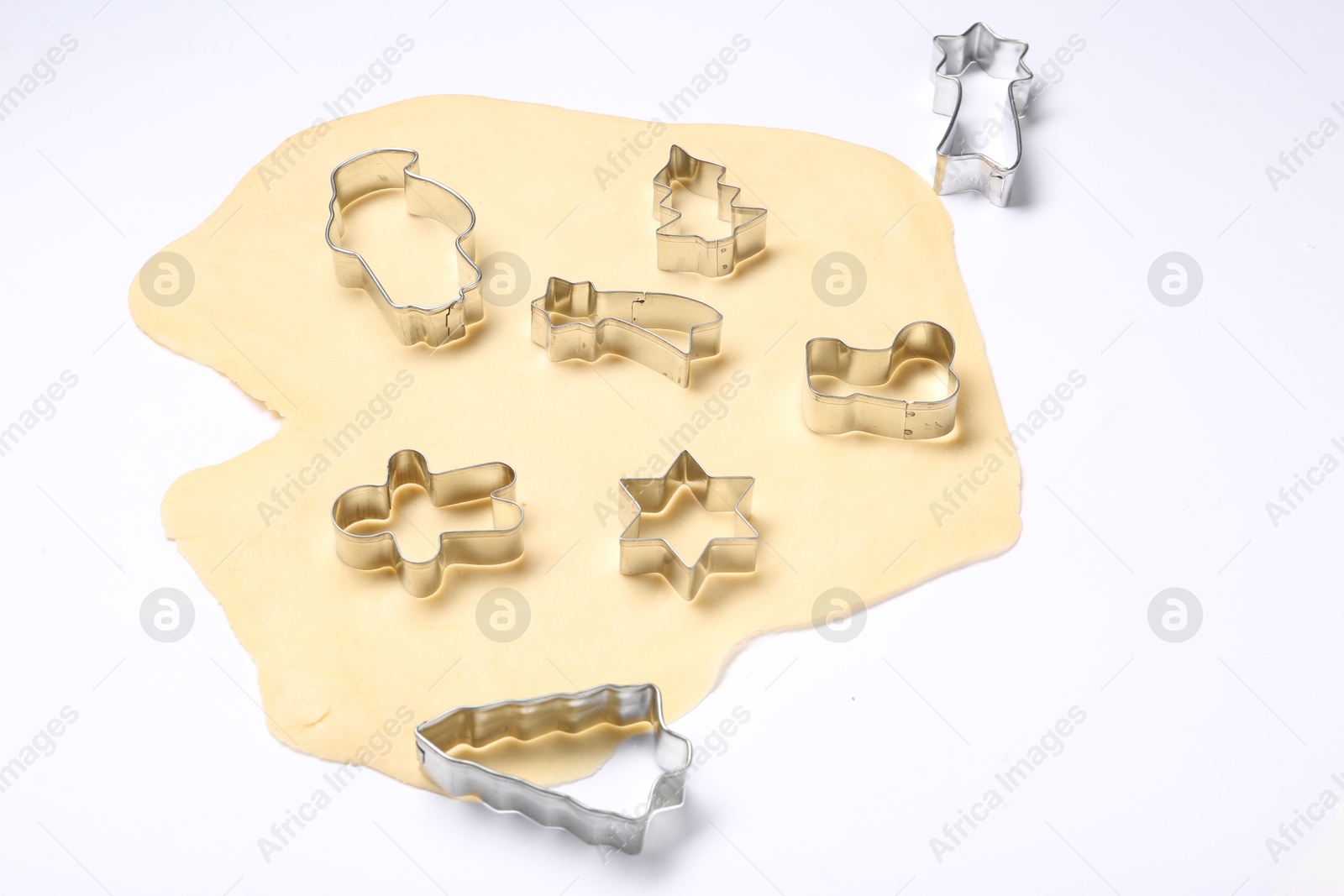 Photo of Raw dough and cookie cutters isolated on white