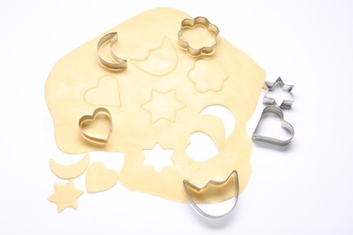 Photo of Raw dough and cookie cutters isolated on white, above view