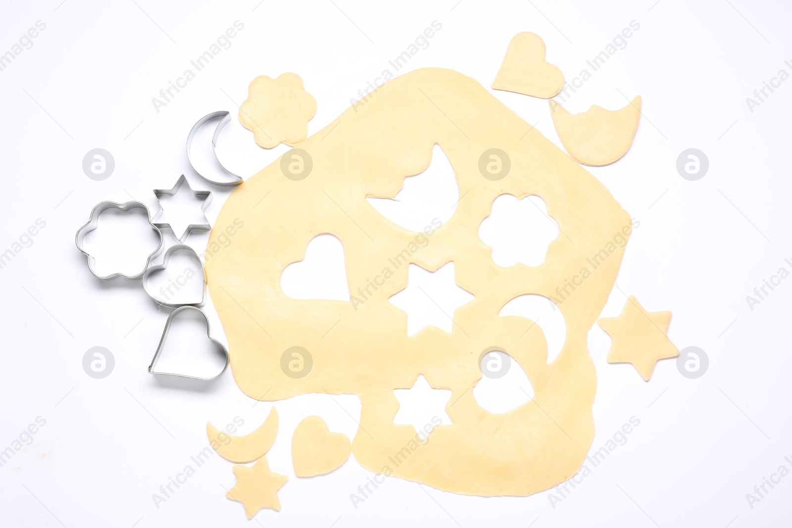 Photo of Raw dough and cookie cutters isolated on white, top view