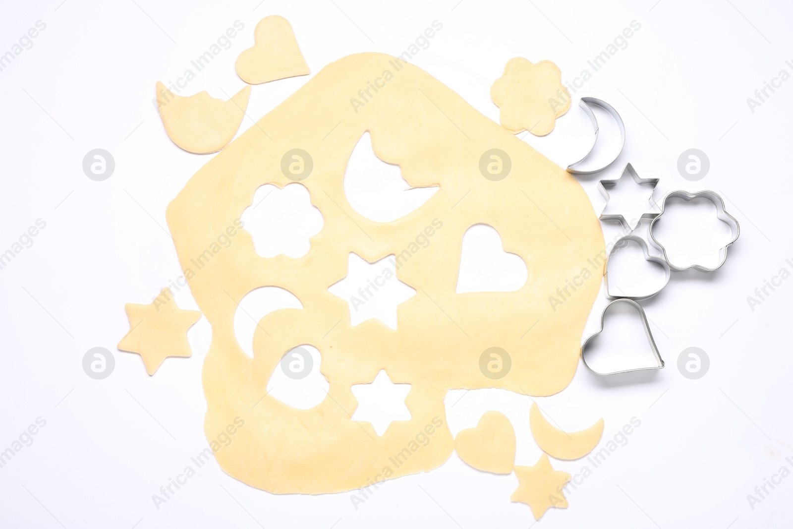 Photo of Raw dough and cookie cutters isolated on white, top view