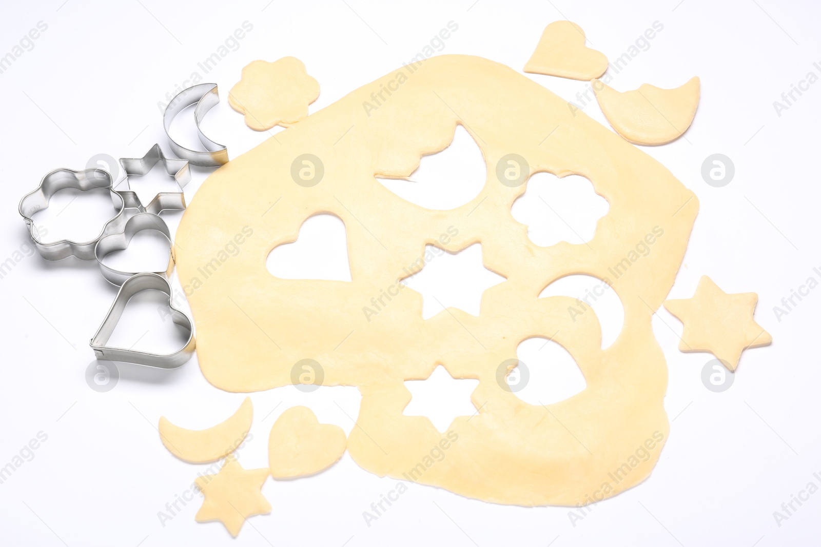 Photo of Raw dough and cookie cutters isolated on white