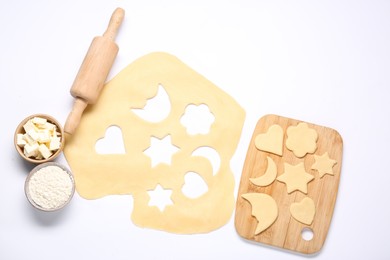 Raw dough, uncooked cookies, flour, butter, rolling pin and board isolated on white, top view